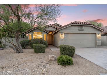Charming single-story home with desert landscaping, red tile roof, and inviting curb appeal at dusk at 14945 N 102Nd St, Scottsdale, AZ 85255