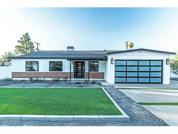 Charming one-story home with a well-manicured lawn and a modern glass garage door at 1539 W Puget Ave, Phoenix, AZ 85021