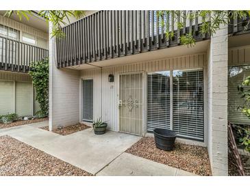 Charming condo featuring a gated front door, large windows, and an upstairs balcony at 1828 W Tuckey Ln # 13, Phoenix, AZ 85015
