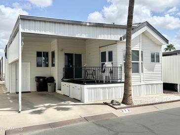 Charming mobile home featuring a covered porch with outdoor seating and tidy, low maintenance landscaping at 272 S Cinnabar Dr, Apache Junction, AZ 85119