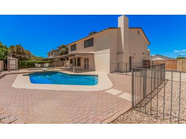 Home's backyard featuring a refreshing pool, outdoor seating area, and well-kept landscaping at 6101 W Sunnyside Dr, Glendale, AZ 85304