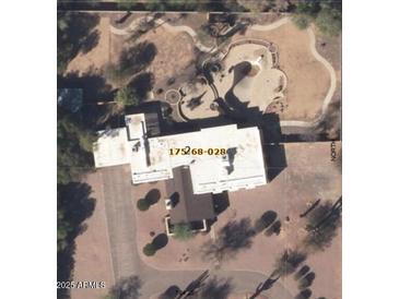 An aerial view of the property, displaying a large white roof and an uniquely designed outdoor pool area with desert landscaping at 6936 E Wethersfield Rd, Scottsdale, AZ 85254