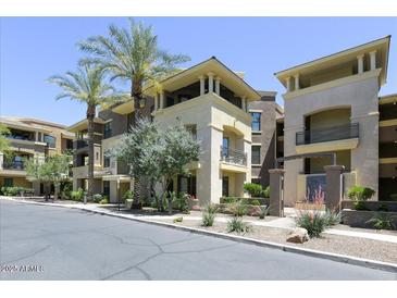 Multi-level building with neutral-colored exterior, balconies, palm trees, and well-maintained landscaping at 7601 E Indian Bend Rd # 1049, Scottsdale, AZ 85250