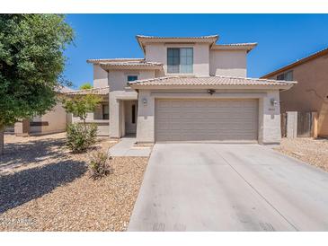 Two-story home featuring a neutral color scheme, two-car garage, desert landscaping, and tile roof at 9352 W Pioneer St, Tolleson, AZ 85353