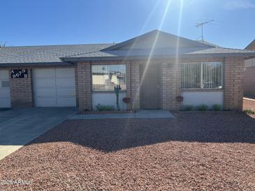 Charming single-story home featuring desert landscaping, brick facade, and attached garage, perfect for comfortable living at 9679 W Cinnabar Ave # B, Peoria, AZ 85345