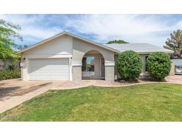 Charming single-story home featuring a well-manicured lawn and an inviting arched entryway at 1241 S Alamo Cir, Mesa, AZ 85204