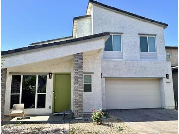 Charming two-story home with a bright green front door and a brick paver driveway at 16027 N 74Th Ln, Peoria, AZ 85382