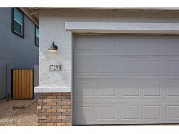 Close up of a large two car garage and lovely brick accent at 17290 W Daley Ln, Surprise, AZ 85387
