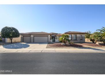 Charming single-story home featuring a three-car garage and desert landscaping for low maintenance at 21003 N Circle Cliffs Dr, Surprise, AZ 85387