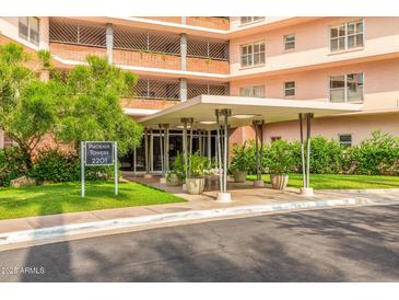 Inviting entrance to Phoenix Towers with covered entry, lush landscaping, and clear signage at 2201 N Central Ave # 3D, Phoenix, AZ 85004