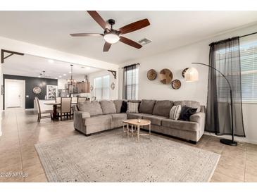 Inviting living room with open floor plan, neutral tones, and tile flooring throughout at 36203 N Urika Dr, San Tan Valley, AZ 85140