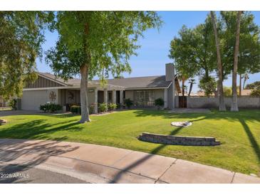 Charming single-story home with lush green lawn and mature trees in a well-maintained neighborhood at 4711 S Los Feliz Dr, Tempe, AZ 85282