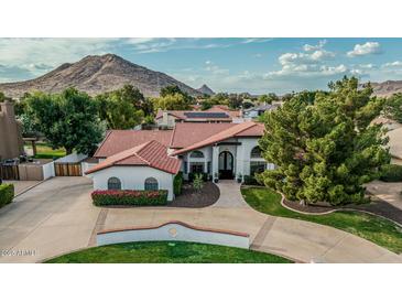 Stunning aerial view of the home showcases its well-manicured front yard and mountain backdrop at 5602 W Alameda Rd, Glendale, AZ 85310