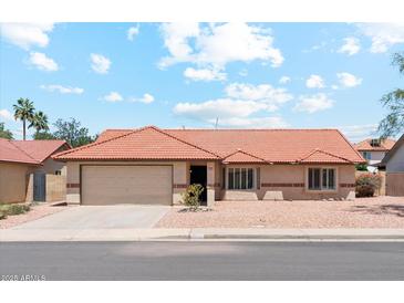 Charming single-story home featuring a tile roof, desert landscaping, and a two-car garage at 5852 E Enrose St, Mesa, AZ 85205