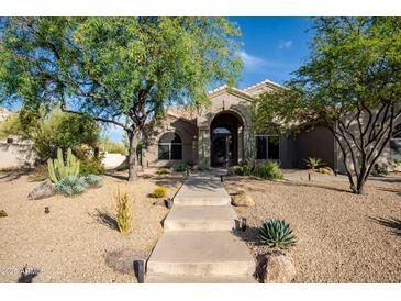 Stunning home featuring professionally landscaped front yard, mature trees, and a stone pathway at 6765 E Duane Ln, Scottsdale, AZ 85266