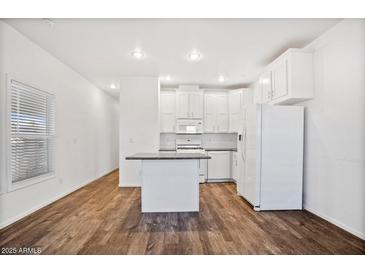 Bright kitchen features white cabinetry, modern appliances, and an island for extra counter space at 7807 E Main St # F36, Mesa, AZ 85207