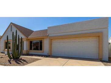 Charming single-Gathering home showcasing low-maintenance desert landscaping and attached two-car garage at 1035 E Wagoner Rd, Phoenix, AZ 85022
