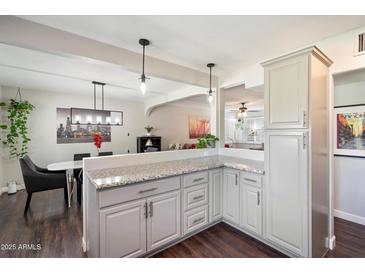 Bright kitchen featuring grey cabinets, granite countertops, and an open design to the adjacent dining area at 1210 W Missouri Ave, Phoenix, AZ 85013