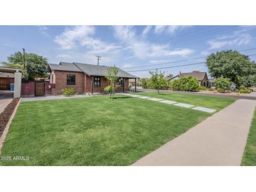 Charming brick home with lush lawn and modern walkway, offering great curb appeal at 1551 W Vernon Ave, Phoenix, AZ 85007