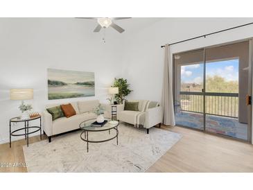 Bright living room with modern decor, stylish furnishings, and a sliding glass door to the balcony at 20801 N 90Th Pl # 271, Scottsdale, AZ 85255
