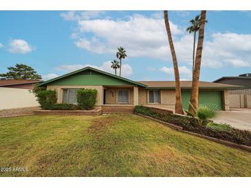 Charming single-story home features a lush front lawn, brick accents, and mature palm trees, creating a welcoming curb appeal at 4530 W Larkspur Dr, Glendale, AZ 85304