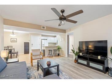 Inviting living room features a ceiling fan, neutral paint, and an adjacent eat-in kitchen at 540 N May -- # 2110, Mesa, AZ 85201