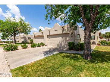 Attractive single-story home featuring a two-car garage, desert landscaping, and a well-maintained lawn at 5445 E Mckellips Rd # 48, Mesa, AZ 85215