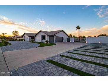 Stunning home featuring a three-car garage and decorative driveway and gate at 5922 W Michelle Dr, Glendale, AZ 85308