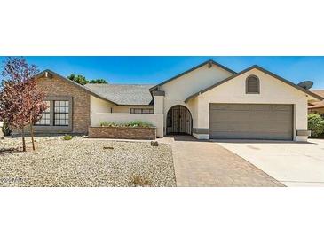 Charming single-story home featuring a two-car garage and low-maintenance desert landscaping in front at 6601 W Montego Ln, Glendale, AZ 85306