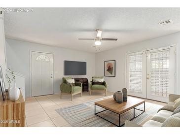 Bright living room with neutral walls, ceiling fan, and lots of natural light at 6901 W Mackenzie Dr # 1287, Phoenix, AZ 85033