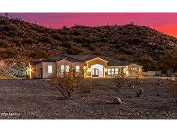 View of desert home with desert landscaping and mountain backdrop during a colorful sunset at 9357 W Canyon Verde Dr, Casa Grande, AZ 85194