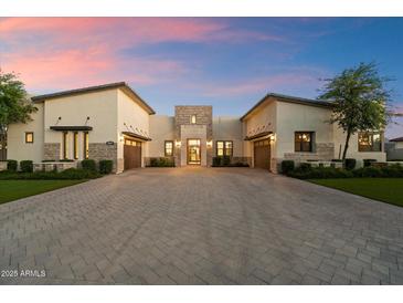 Expansive driveway leading to a luxury home with attached garages and stone accents under a beautiful sunset at 19917 E Natalie Way, Queen Creek, AZ 85142