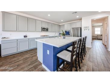 Stylish kitchen featuring a spacious island, ample counter space, and modern appliances at 25051 N 140Th Dr, Surprise, AZ 85387
