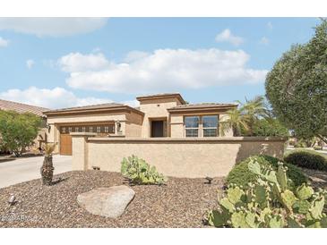 A tan single-story home features desert landscaping, a private courtyard, and an attached two-car garage at 27023 N 130Th Gln, Peoria, AZ 85383