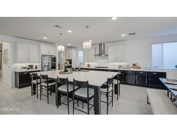 Well-designed kitchen featuring a large island with seating, quartz countertops, and stylish pendant lights at 4507 S 119Th Dr, Avondale, AZ 85323