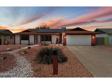 Charming single-story home with desert landscaping, solar panels, and a two-car garage at 5808 W Acoma Dr, Glendale, AZ 85306