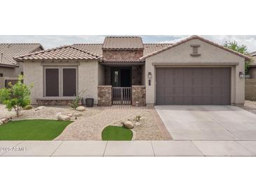 Charming home exterior featuring a well-manicured lawn, a brick walkway, and a two-car garage at 9041 W Redbird Rd, Peoria, AZ 85383