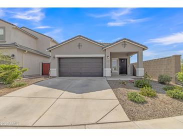 Charming single-story home with a well-maintained front yard, spacious driveway, and a two-car garage at 10004 S Smythe Dr, Apache Junction, AZ 85120