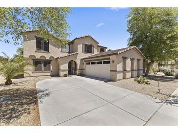 Charming two-story home featuring a three-car garage and a well-maintained front yard with mature trees at 18390 W Hayden Dr, Surprise, AZ 85374