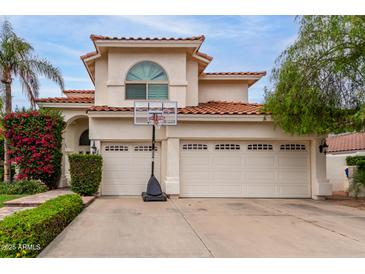 Charming two-story home with a three-car garage, red tile roof, basketball hoop and beautiful desert landscaping at 2026 E Cortez Dr, Gilbert, AZ 85234