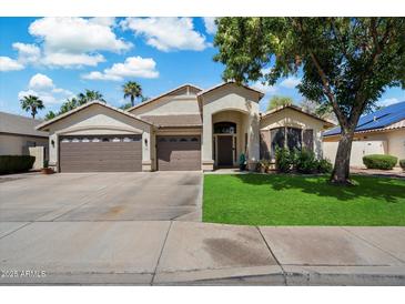 Charming single-story home featuring a three-car garage and a well-manicured front yard with vibrant green grass at 420 S Dodge Dr, Chandler, AZ 85225