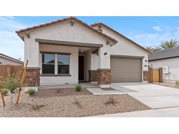 Charming single-story home featuring a two-car garage, covered porch, and low maintenance desert landscaping at 42405 W Peters Dr, Maricopa, AZ 85138