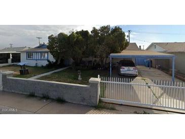 Charming single-story home with a covered carport and mature trees at 5833 W Rosewood Ln, Phoenix, AZ 85031