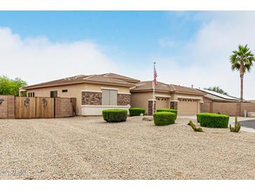 Charming single-story home featuring manicured landscaping with a spacious front yard and rock accents at 18247 N 168Th Cir, Surprise, AZ 85374