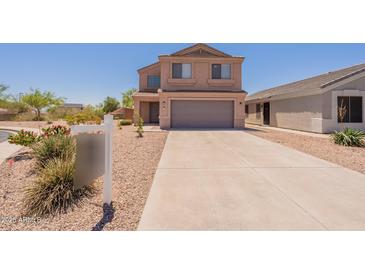 Two-story home featuring a neutral stucco exterior, gray garage door, and low-maintenance landscaping at 23929 W Twilight Trl, Buckeye, AZ 85326