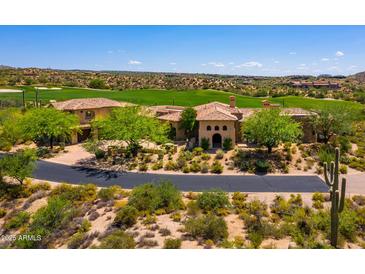 Stunning view of the tile roofed luxury home set adjacent to a lush golf course and beautiful desert landscape at 40853 N 94Th St, Scottsdale, AZ 85262