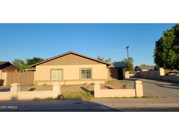 Charming single-story home with a neutral facade, low block wall, and desert landscaping at 5739 N 62Nd Dr, Glendale, AZ 85301