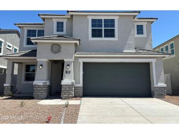 Charming two-story home featuring a gray stucco exterior, a two-car garage, and a well-manicured front yard at 7404 W Buckhorn Trl, Peoria, AZ 85383
