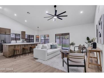 Bright living room featuring an open floor plan, ceiling fan, and sliding glass door to the backyard at 1142 E Encinas Ave, Gilbert, AZ 85234