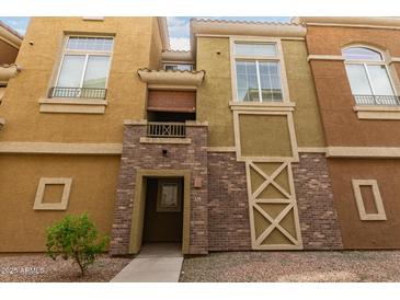 Charming townhome with a brick entryway, covered balcony, and desert landscaping at 18250 N Cave Creek Rd # 139, Phoenix, AZ 85032